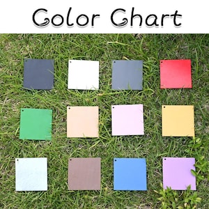 May include: A color chart featuring twelve square swatches arranged in a grid. Each square has a small hole in the top left corner. The colors include black, white, gray, red, green, beige, light pink, yellow, light gray, brown, blue, and purple.