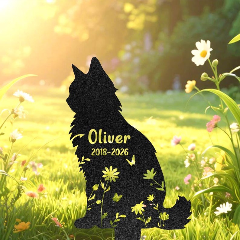 May include: A black cat-shaped silhouette garden stake featuring the name Oliver and the years 2018-2026 printed in yellow. The surface of the cat silhouette is decorated with yellow floral patterns and small butterfly graphics throughout the design.