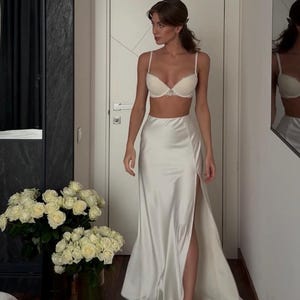 Satin corset with molded cups and adjustable straps paired with long flowing maxi skirt with side slit, high waist, elegant two-piece outfit for evening or special occasion