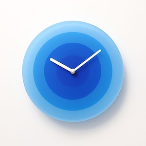 May include: A circular wall clock with a blue gradient design. The clock face has concentric circles in shades of blue. White clock hands show the time. The clock is a modern, minimalist design, suitable for any room. The clock's diameter is approximately 25 cm.