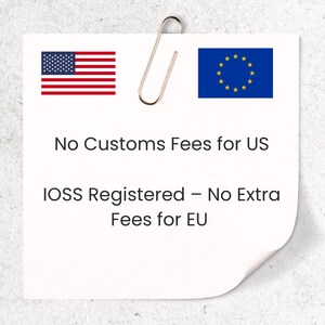 Puede incluir: Una nota adhesiva blanca con un clip dorado, la bandera de EE. UU. y la bandera de la UE. El texto dice "Sin tasas de aduana para EE. UU." y "Registrado en IOSS - Sin tarifas adicionales para la UE".