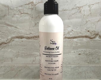 May include: A white bottle of Batana Oil hydrating leave-in mist with a black spray nozzle. The label includes text that reads "MOISTURIZES & RESTORE HAIR LUSTER, PROMOTES HAIR GROWTH, PROTECTS HAIR." The bottle contains 8 oz of product.
