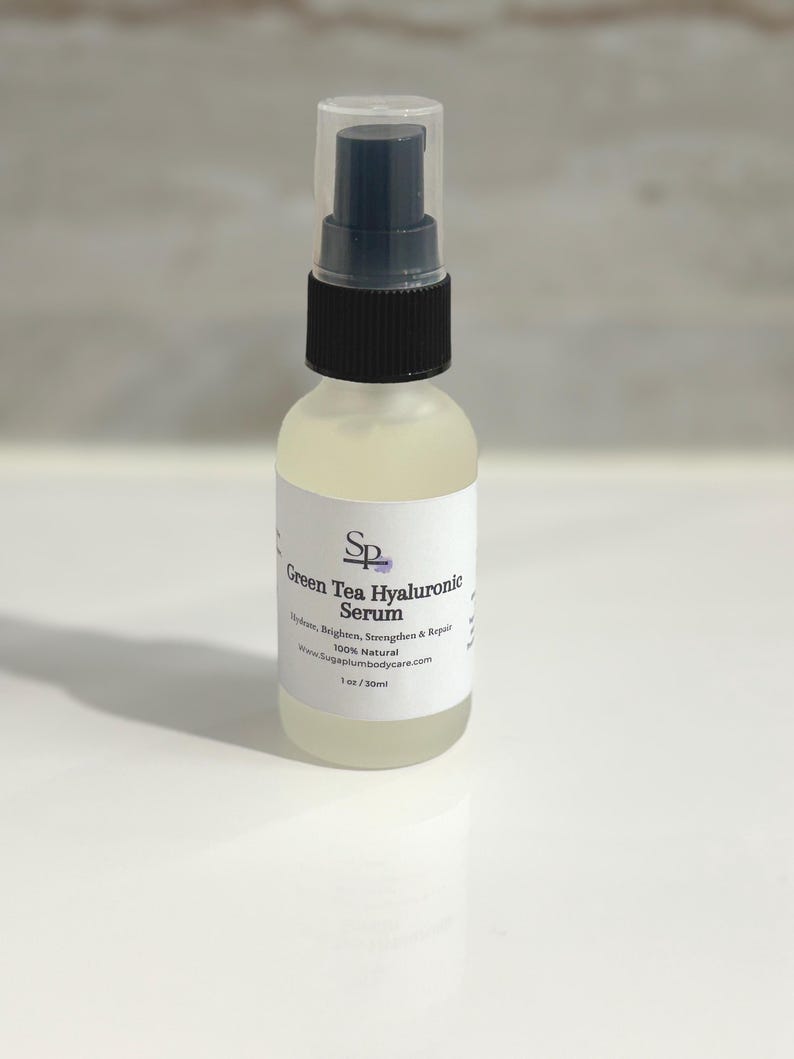 May include: A clear glass bottle of Green Tea Hyaluronic Serum with a black and clear spray top. The label reads "Green Tea Hyaluronic Serum" and "Hydrate, Brighten, Strengthen & Repair". The bottle contains 30ml of serum.