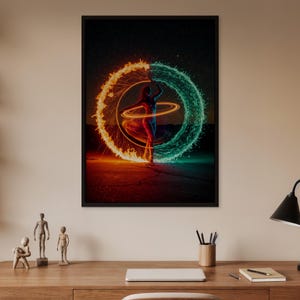 May include: A framed art print depicts a person standing between a fiery orange and a teal water-like energy circle. The person is surrounded by glowing light trails, with a dark night sky background. The artwork is displayed on a wooden desk.