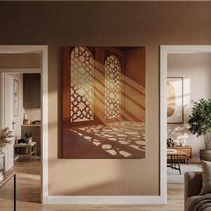Puede incluir: Una impresión en lienzo que representa una escena interior con dos ventanas arqueadas. La luz del sol atraviesa las ventanas estampadas, proyectando intrincadas sombras en el suelo. La paleta de colores es cálida, con tonos marrones y dorados.
