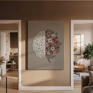 May include: A canvas print depicting a human brain split in half. One side is a detailed illustration of the brain, the other is filled with pink and white flowers. The artwork is displayed on a neutral-toned wall.