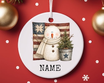 Adorno navideño de cerámica personalizado con forma de muñeco de nieve patriótico, ideal para regalar o como etiqueta para calcetín navideño.