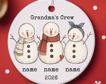 Adorno navideño de cerámica personalizado "El equipo de la abuela" con muñecos de nieve, ideal para regalar o como recuerdo.