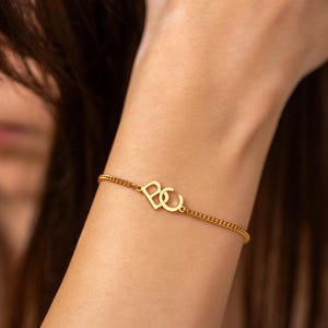 Op de afbeelding: Handgemaakt houten bord met de tekst "Welcome" in een sierlijk lettertype. Het bord is wit geschilderd met een verweerde afwerking en heeft een bloemenontwerp in roze en groen. Geschikt voor binnen en buiten.