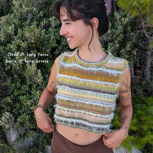 Pode incluir: Um top de malha sem mangas listrado multicolorido, com tons de amarelo, verde, marrom e azul. A borda inferior tem uma textura difusa. O texto "Cloud 01 Lang Yarns Basta 01 Lana Grossa" é visível.