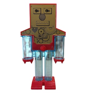 May include: A robot-shaped kitchen measuring tool with a gold-colored face featuring black line art of eyes, a nose, and a mouth. The body is red plastic with four clear cylindrical measuring tubes marked with imperial units in ounces and cups.