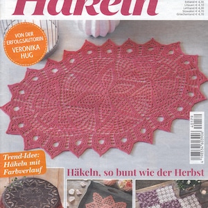 May include: A white ceramic mug with a black handle and the text "But First, Coffee" in a bold, black font. The mug is set against a blurred background, suggesting a cozy setting.