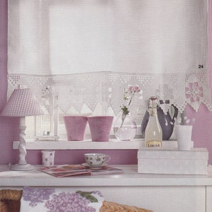 Può includere: Una tenda bianca a uncinetto con una parete rosa dietro. Ci sono tre vasi rosa, un vaso di vetro con fiori, una bottiglia di vetro con un'etichetta che dice "Lorina", una brocca grigia e una tazza bianca su uno scaffale bianco. C'è una rivista e una tazza bianca su un tavolo bianco.