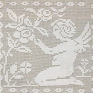 May include: A close-up of a white crocheted doily with a detailed floral pattern. The intricate design features a central motif surrounded by a border of repeating shapes. The doily is made of a soft, textured yarn.