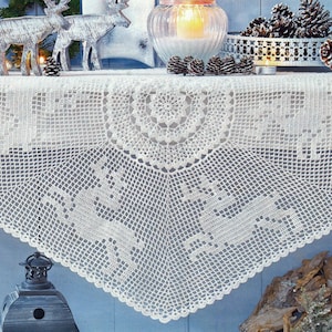 May include: A white, crocheted table runner with a decorative deer pattern. The runner is draped over a shelf, with decorative items such as deer figurines, pine cones, and a candle holder. The runner's intricate design adds a touch of elegance.