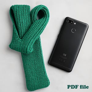 May include: A bright green knitted scarf with a loop design, next to a black smartphone. The scarf is made of a thick, textured yarn. The image also includes the text "PDF file".