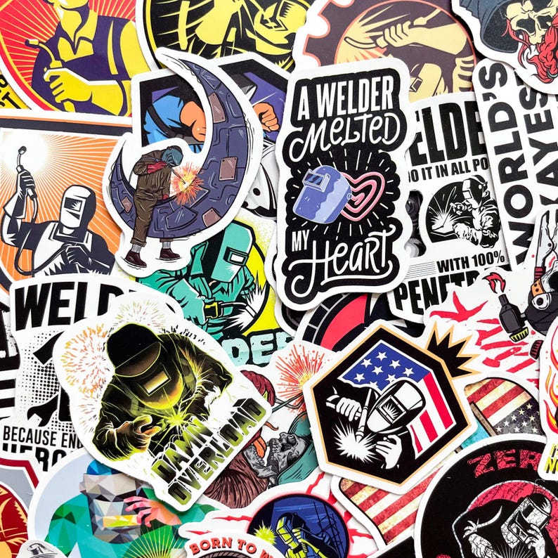 May include: A collection of colorful stickers featuring welding-themed designs. The stickers showcase welders, welding masks, sparks, and text like "A Welder Melted My Heart" and "Danger Overload". The designs incorporate red, blue, and yellow.