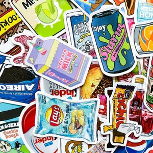 May include: A collection of colorful stickers featuring various designs. Notable stickers include a blue soda can with "Slurm" text, a "Unicorn Milk" carton, a bag of "Lay's Salt & Vinegar" chips, and a candy bar.