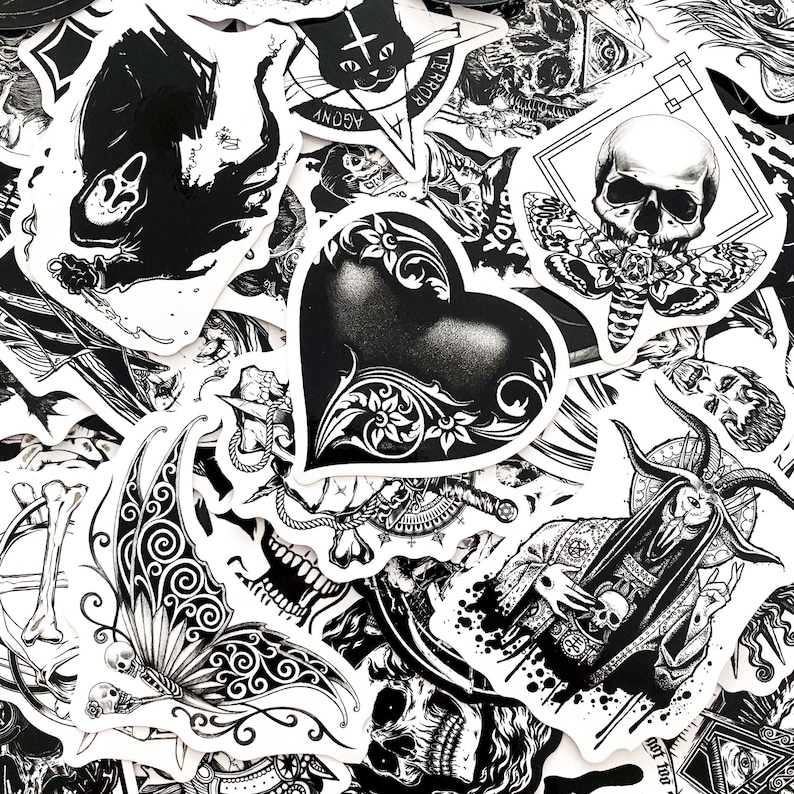 May include: A collection of black and white stickers with gothic and occult themes. Designs include skulls, moths, a heart with floral accents, and illustrations of demons and other dark imagery. The stickers are arranged in a random pattern.