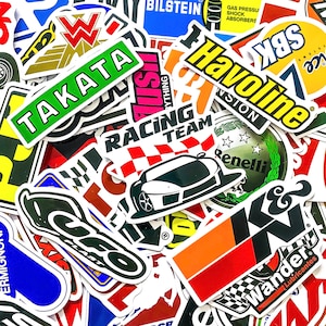 Peut inclure: Un ensemble d'autocollants colorés représentant diverses marques automobiles et des motifs de course. Les autocollants incluent des logos et du texte tels que "TAKATA", "Havoline" et "Racing Team". Les autocollants sont de formes et de tailles variées.