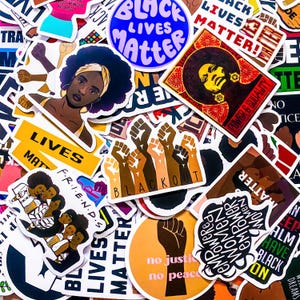Peut inclure: Une collection d'autocollants avec divers motifs et messages. Les autocollants présentent des images de femmes noires, des poings levés et des phrases telles que « Black Lives Matter », « Power & Equality » et « No Justice No Peace ». La palette de couleurs comprend le noir, le blanc, le jaune et le marron.