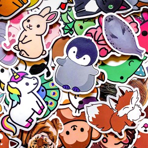 May include: A collection of colorful stickers featuring various animals. Includes a light brown bunny, a gray penguin, a white unicorn with a rainbow mane, and a brown fox. Other stickers include a seal, a tiger, and a monkey.