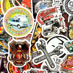 May include: A collection of vintage-style stickers featuring classic cars, garage themes, and automotive-related graphics. Includes a 1965 Plymouth Satellite sticker, a "Shelby's" sticker, and crossed wrench stickers. The stickers have a distressed, retro aesthetic.