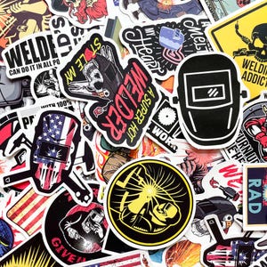 May include: A collection of colorful stickers with welding-themed designs. The stickers feature images of welding masks, skulls, and text like "Welder," "A Super Hot," and "Welding Addict." The color palette includes red, yellow, black, and white.