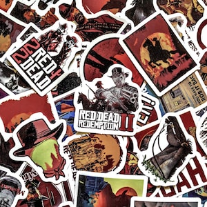 Può includere: Una collezione di adesivi di Red Dead Redemption II. Gli adesivi presentano immagini di cowboy, cavalli e il logo del gioco in rosso, nero e bianco. Alcuni adesivi hanno testo come "Red Dead Redemption II".