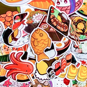 May include: A collection of colorful stickers featuring various Japanese food illustrations. The stickers include sushi, ramen, tempura, and a fish-shaped pastry. The designs are vibrant and detailed, with a cartoonish style.