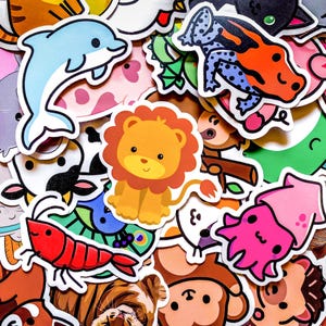 May include: A collection of colorful animal stickers, including a blue dolphin, a lion, a red shrimp, and a pink squid. The stickers are various sizes and shapes, with a white border.