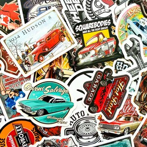 May include: A collection of vintage car-themed stickers. The stickers feature classic cars, garage and hot rod designs, and text such as "Owens Salvage" and "Hot Rod Motor Club". The color palette includes red, blue, and white.
