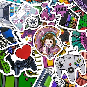 May include: A collection of colorful stickers with a gaming theme. Designs include game controllers, a cartoon girl in a donut, a heart, and text that says "LOUD" and "and PROUD". The stickers are in various shapes and sizes.