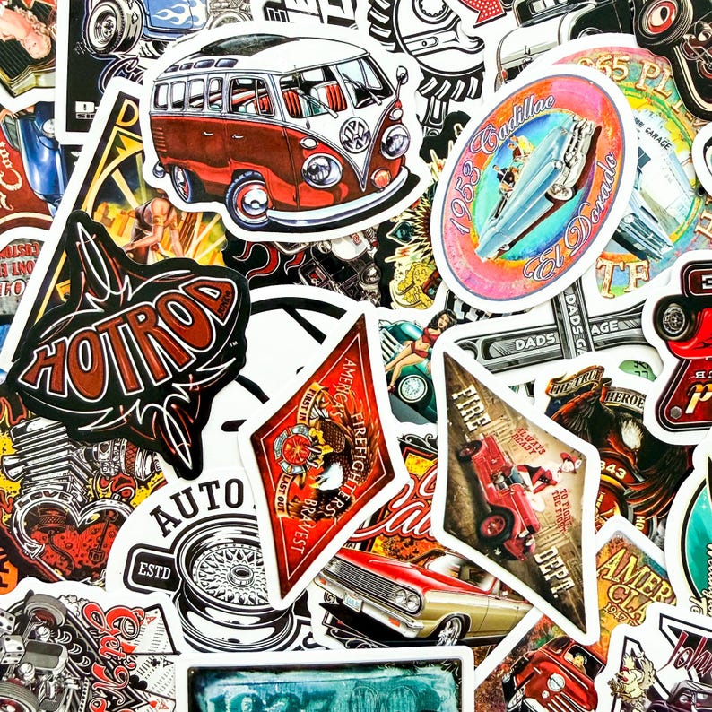 May include: A collection of vintage-style stickers featuring classic cars, a VW bus, and various automotive-themed graphics. The stickers are in various shapes and sizes, with a mix of colors including red, white, and black. Some stickers have text like "Hot Rod" and "Cadillac El Dorado".