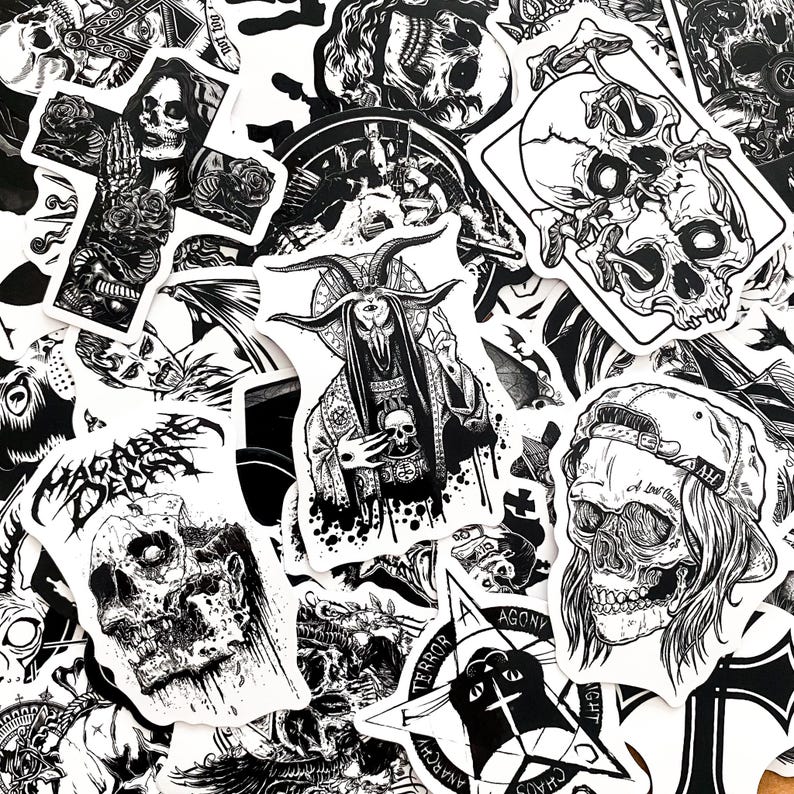 May include: A collection of black and white stickers featuring gothic and occult imagery. Designs include skulls, demons, crosses, and other dark art illustrations. The stickers vary in size and shape, with intricate details.