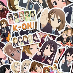Pode incluir: Uma cole&ccedil;&atilde;o de autocolantes em estilo anime com personagens da s&eacute;rie "K-ON!". Os autocolantes mostram v&aacute;rios personagens em diferentes poses e roupas, com o logotipo do programa em destaque. Os autocolantes s&atilde;o coloridos e detalhados.