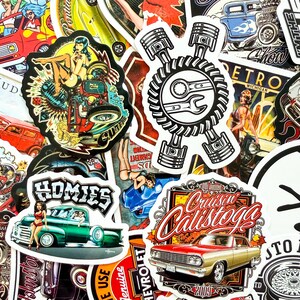 May include: A collection of colorful stickers with vintage car and pin-up girl designs. The stickers feature text like "Cruisin' Calistoga", "Homies", and "Retro Michigan". The color palette includes red, green, gold, and blue.