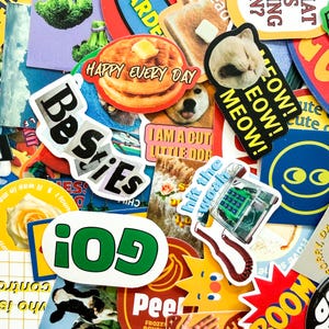 May include: A vibrant collection of stickers with diverse designs and text. Key stickers include a stack of pancakes with butter, a sleeping cat with "MEOW!" text, and the word "Besties". Other stickers feature a dog, a telephone, and the word "GO!"