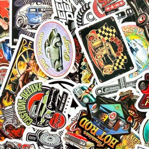 May include: A collection of vintage-style stickers featuring classic cars, hot rods, and automotive-themed designs. The stickers showcase various colors, including red, black, and blue, with text such as "American Hot Rod" and "Custom Deluxe".