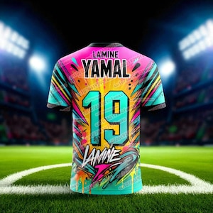 May include: A vibrant soccer jersey with a colorful abstract design. The jersey features the name "YAMAL" above the number "19" in large, bold letters. The name "LAMINE" is printed at the bottom. The shirt's design incorporates splashes of pink, teal, yellow, and black.