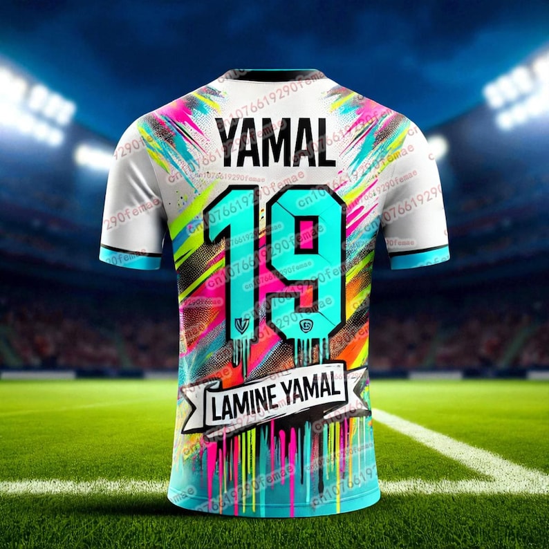 May include: White soccer jersey with the name "YAMAL" and the number "19" in teal. The jersey has a colorful design with pink, blue, and yellow accents. The name "LAMINE YAMAL" is displayed on a banner.