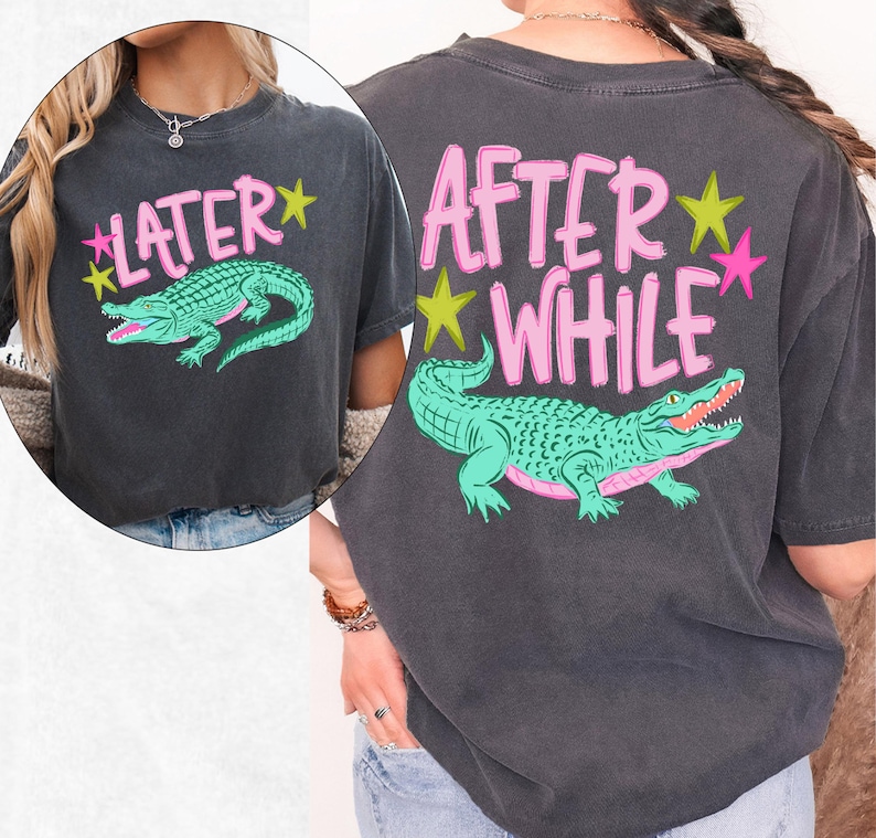 May include: Dark gray t-shirt with a teal alligator graphic and the text "LATER" on the front and "AFTER WHILE" on the back, in pink lettering with yellow and pink star accents. The shirt has a vintage, worn look.