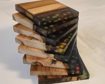 Set van 8 onderzetters van walnoothout en epoxyhars met gedroogde bloemen.