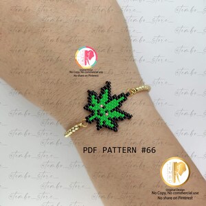 Puede incluir: Una pulsera dorada con un diseño de cuentas. La pulsera presenta un dije en forma de hoja verde y negra con acentos rosas. El texto "PDF PATTERN #66" es visible en la imagen.