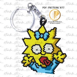 Może przedstawiać: Żółto-niebieski brelok z koralików przedstawiający postać z kreskówki z kokardą. Brelok ma srebrny pierścień i czarny sznurek. Widoczny jest tekst "PDF@PATTERN #77".