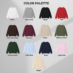 May include: A color palette of crewneck sweatshirts in various colors, including white, sport grey, black, red, dark chocolate, maroon, sand, military green, forest green, light blue, navy, light pink, and beige. The text "COLOR PALETTE" is at the top.