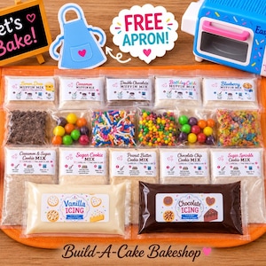 May include: A baking kit featuring an Easy-Bake oven, a chalkboard sign reading Let's Bake!, various muffin and cookie mix packets, colorful sprinkles, vanilla and chocolate icing pouches, and measuring spoons on an orange mat.