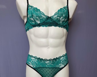 May include: A teal green lingerie set on a mannequin. The set includes a lacy bra with black straps and matching high-waisted bottoms. The bottoms have a dotted mesh panel in the front and black trim.