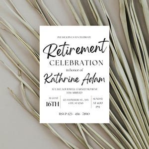 May include: A white invitation card with black text, announcing a retirement celebration for Kathrine Adam. The card includes the date, time, and RSVP information. The background features dried, light-colored plant stems.