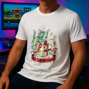 Puede incluir: Camiseta blanca con un gatito de dibujos animados a rayas verdes, sentado sobre una caja de regalo con la etiqueta "repo". La caja está envuelta con una cinta roja y rodeada de etiquetas "Commit Note". El texto "Git Gift Wrapped" está debajo.
